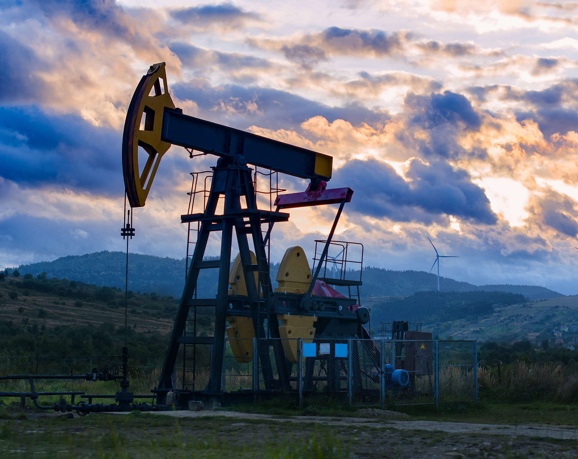 oil well with sunset sky behind it